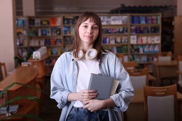 Portrait of beautiful woman with books in library