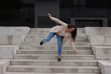 Woman falling on stairs outdoors. Dangerous accident
