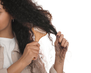 Woman brushing her curly hair on white background, closeup