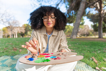 Young black woman painting outdoors captures creativity in the park