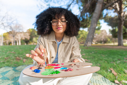 Young black woman painting outdoors captures creativity in the park