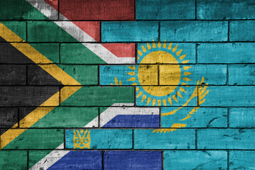 Fototapeta premium colourful painted big flag of south africa and flag of kazakhstan on a massive old brick wall background. concept