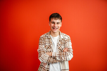 Fototapeta premium portrait of man stand arm crossed in front red background studio shot