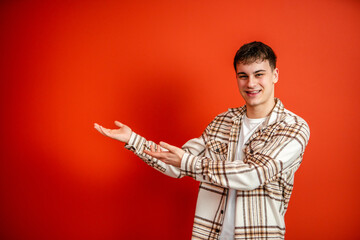 portrait of man stand and show red background behind him studio shot