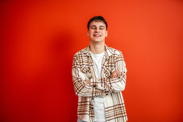 portrait of man stand arm crossed in front red background studio shot