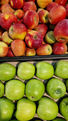Apples for sale in a supermarket. Green and red apples close-up with selective focus. Fruits. A pile of apples for sale in a store. A variety of fresh apples on a supermarket counter