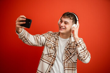 man with headphones studio shot on red background take a self portrait