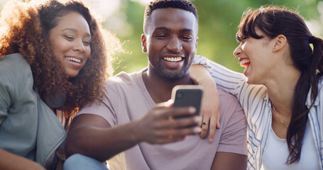 Phone, happy and group of friends in nature browsing on social media for celebrity gossip....