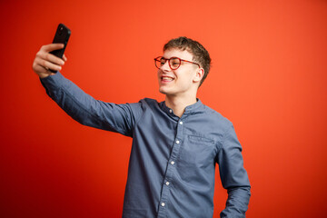 young man studio shot on red background take a self portrait