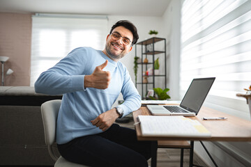 Man Sitting at Desk Giving Thumbs Up