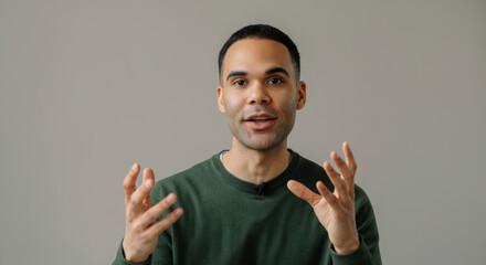A man with a green shirt is talking to the camera
