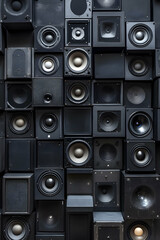 A wall of black speakers arranged in a grid, perfect for showcasing music production, sound design, or audio technology themes