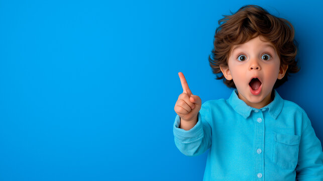 Playful boy pointing to the side, showing excitement and enthusiasm, capturing themes of exploration, guidance, and youthful confidence, ideal for branding that promotes learning and engagement.