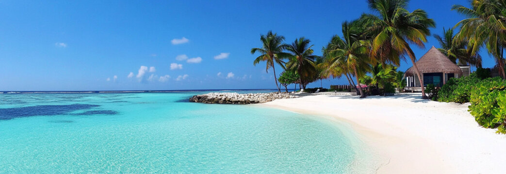 Landscape format of a paradisiac beach with a beautiful sea color and white sand on a perfect sunny day