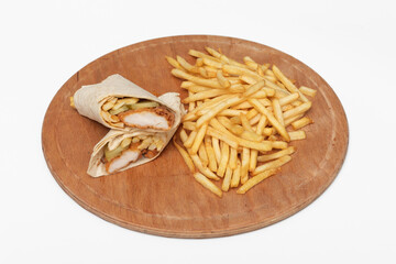 Tortilla wrap with chicken and french fries on a wooden board