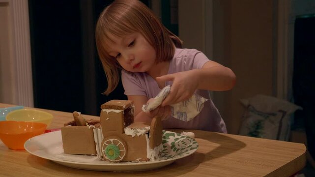 Little Girl Making a Gingerbread Train For the Holidays