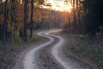 Fototapeta premium A dirt road meanders into the glow of a golden sunset, showcasing the beauty of nature and the promise of adventure as the day draws to a close.