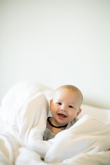 Portrait, kids and mockup with a baby in a bedroom, sitting on a bed in his home for child development. Children, babies and blanket with an adorable newborn infant boy in a house for growth or care