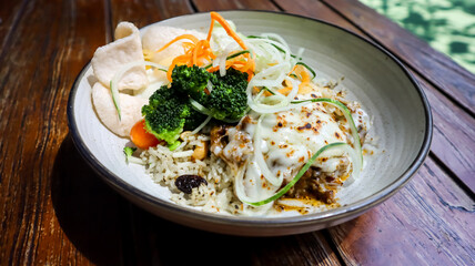 A plate of baked rice with beef mozarella, vegetables and crackers