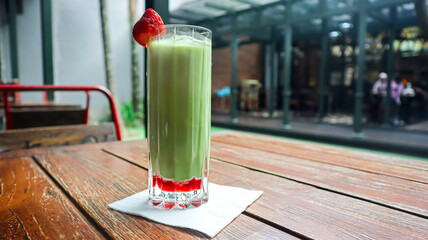 A glass of matcha, garnished with strawberry