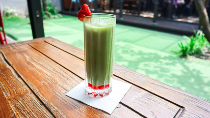 A glass of matcha, garnished with strawberry