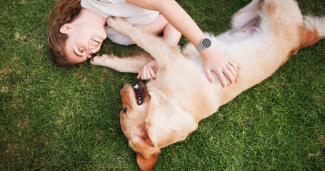 Happy woman, relax and lying with dog above on grass field for bonding, love and support at park. Top view, female person or pet owner with labrador, golden retriever or playful companion in nature © peopleimages.com