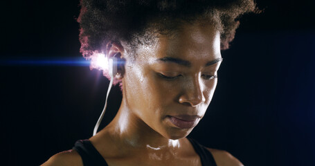 Earphones, fitness and face of black woman in studio for intense training, exercise and workout....