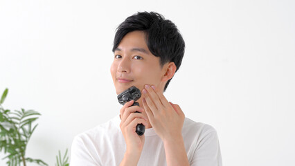 シェーバーで髭を剃る男性