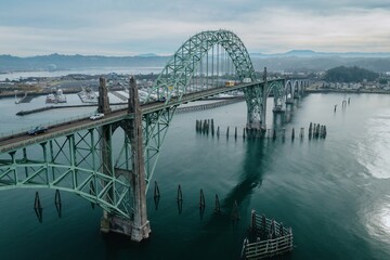 High-angle view of the Yaquina Bay Bridge, spanning the River. Cars travel across the bridge, showcasing the impressive structure. Newport, Oregon, USA
