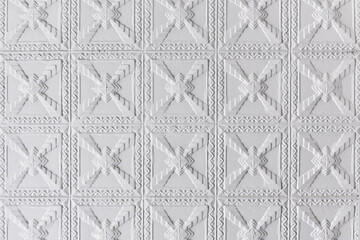 The square geometric grid pattern of a pressed steel roof installation.