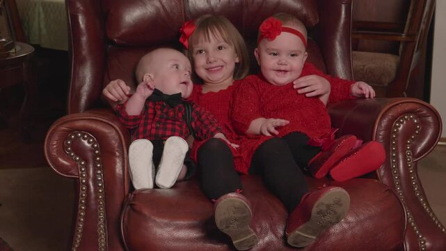 Cute Kids Sitting on a Chair for a Photo
