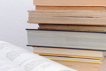 Lots of books stacked in a minimalist and clean environment. Old and modern books organized for reading. Collection of books in home library.