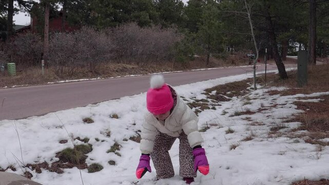 Little Girl in Snow Suite Throwing Snow