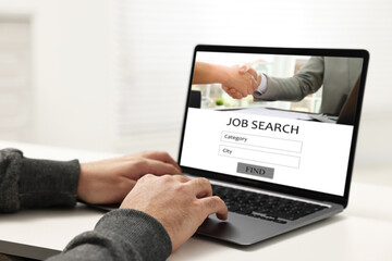 Job search. Man using employment website on laptop at home, closeup