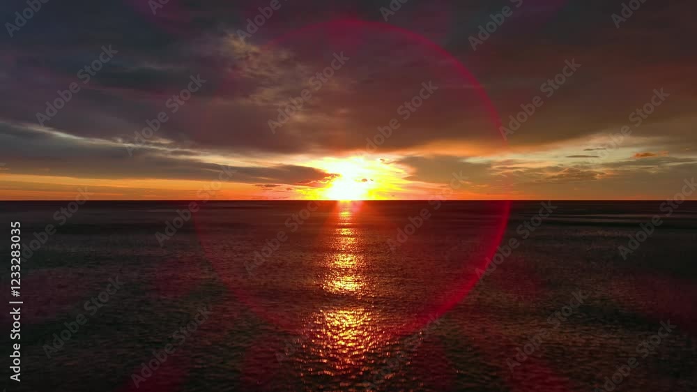 Wall mural aerial view of sea surface during a dramatic red sunset, 4k