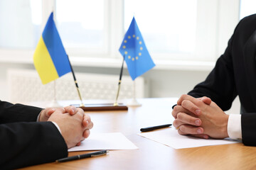 Diplomats negotiating during meeting at table indoors, closeup