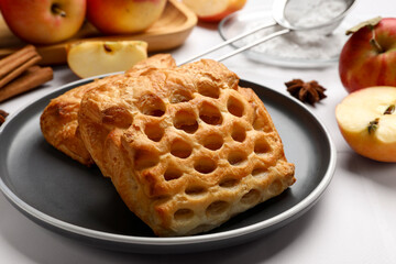 Delicious puff pastries and apples on white table, closeup