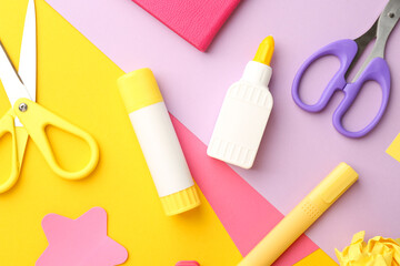 Flat lay composition with glue, scissors and other stationery on color background