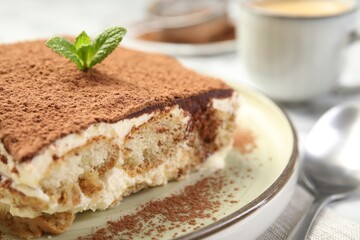 Piece of tasty tiramisu on white table, closeup
