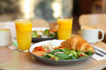 Tasty breakfast. Different meals and drinks served on wooden table in cafe, closeup