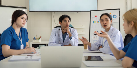 Fototapeta premium Diverse healthcare professionals discussing patient care strategies in a meeting.