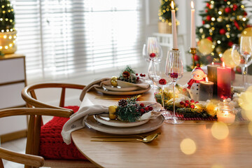 Christmas celebration. Festive table setting with dishware, glasses and decor in room