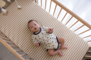 Newborn baby boy relaxing on the cot