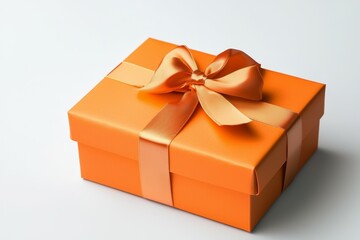 Obraz premium Large orange box with a gold ribbon tied around it