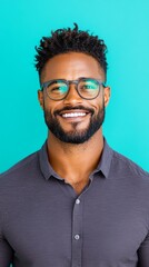 Obraz premium Smiling Black man in glasses against a teal background.