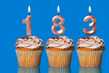 Birthday Cupcakes With Candles Lit Forming The Number 183.
