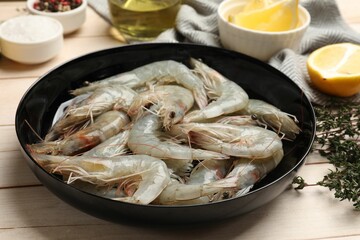 Fresh raw shrimps and spices on wooden table, closeup