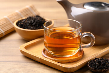 Black tea in cup glass with dried tea leaves, Healthy herbal drink