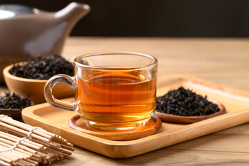 Black tea in cup glass with dried tea leaves, Healthy herbal drink