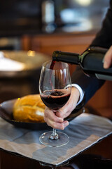 Hand Pouring Red Wine Into an Empty Glass
